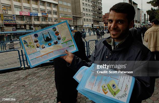 Young Iranian man hands out posters with the image of Jamkaran Mosque, where some Shiite Muslims believe they can be close to the 12th Imam, the...