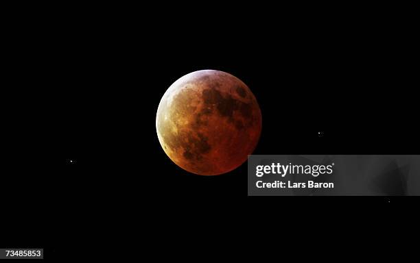 The moon glows red in the shadow of the earth during the total lunar eclipse on March 3, 2007 in Dinslaken, Germany. The eclipse began at 2018 GMT,...