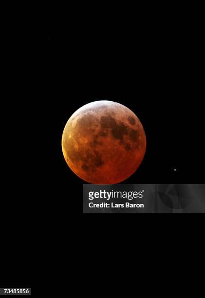 The moon glows red in the shadow of the earth during the total lunar eclipse on March 3, 2007 in in Dinslaken, Germany. The eclipse began at 2018...
