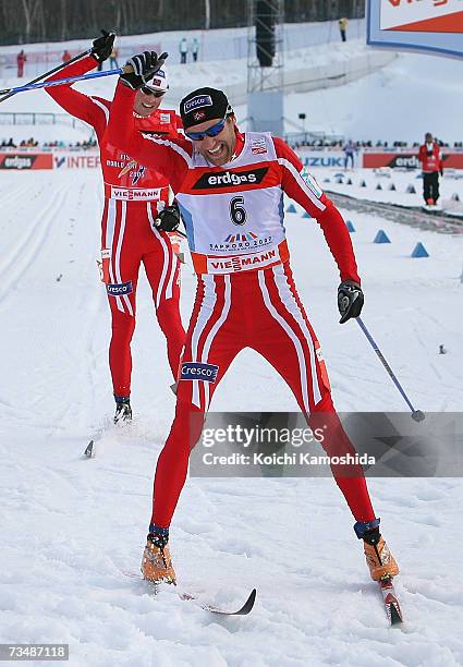 Odd-Bjoern Hjelmeset of Norway celebrates winning the Gold Medal next to compatriot Frode Estil in the Mens Cross Country Skiing 50km classical Mass...