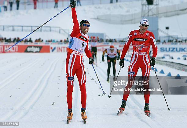 Odd-Bjoern Hjelmeset of Norway celebrates winning the Gold Medal next to compatriot Frode Estil in the Mens Cross Country Skiing 50km classical Mass...