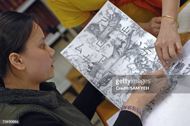 Vietnamese woman who married a Taiwanese man learns the pronunciation of Chinese Mandarin during a language course in Taipei, 05 February 2007. Some...