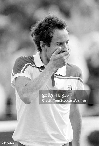 American tennis player John McEnroe puts his hand to his mouth during a disputed decision with a Wimbledon umpire, London, June 1983. McEnroe went on...