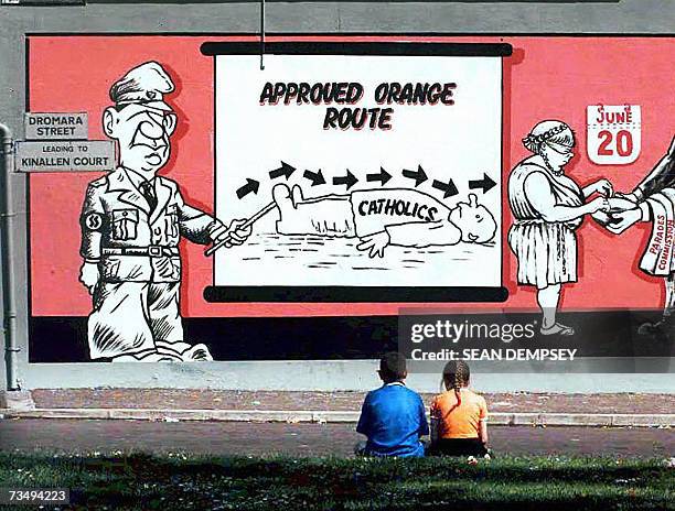 United Kingdom: This picture taken 09 July 1997 shows children looking at a mural on a wall on the Lower Ormeau Road, South Belfast, expressing...