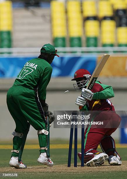 West Indies Chris Gayle clean bowled by Kenya's Hiren Varaiya as Wicket Keeper Maurice Ouma looks on, during the warm-up match between West Indies...