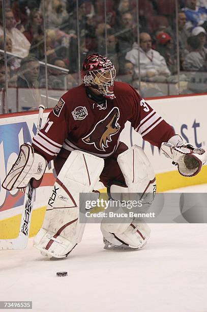 Goaltender Curtis Joseph of the Phoenix Coyotes controls the puck behind the net against the Columbus Blue Jackets during their NHL game on March 3,...