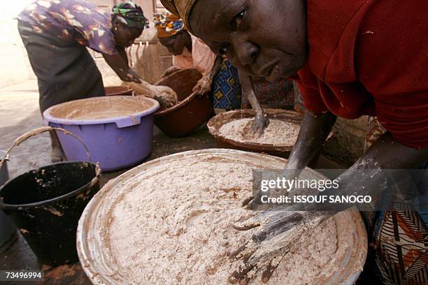 Ouagadougou, BURKINA FASO: Women from a cooperative prepare 02 March 2007 shea butter in a neighborhood of Ouagadougou. As cosmetics containing shea...