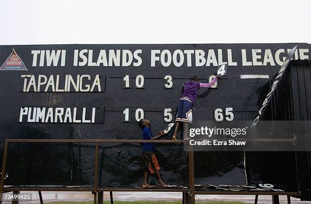 Tiwi Island residents adjust the scoreboard during an Australian Rules football match at their local oval March 5, 2007 on the Tiwi Island,...
