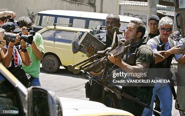 Rio de Janeiro, BRAZIL: A member of a Brazilian special police unit carries an old 7.62 caliber Browning machine gun seized after an anti-drug...