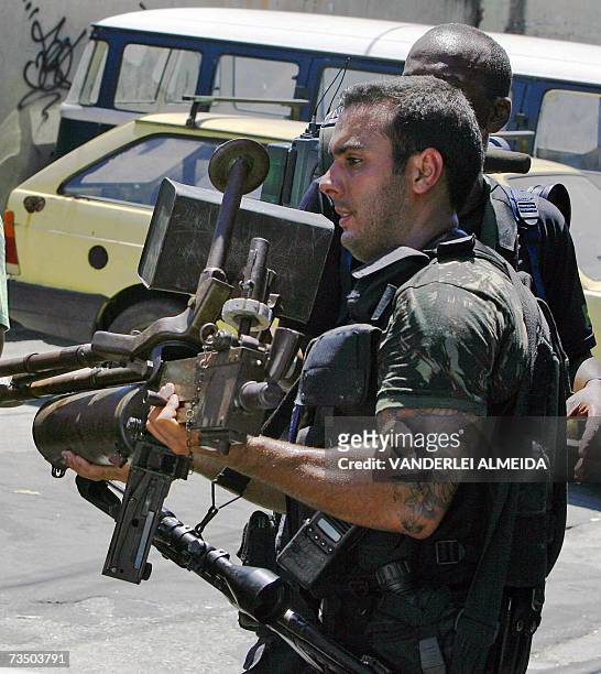 Rio de Janeiro, BRAZIL: A member of a Brazilian special police unit carries an old 7.62 caliber Browning machine gun seized after an anti-drug...