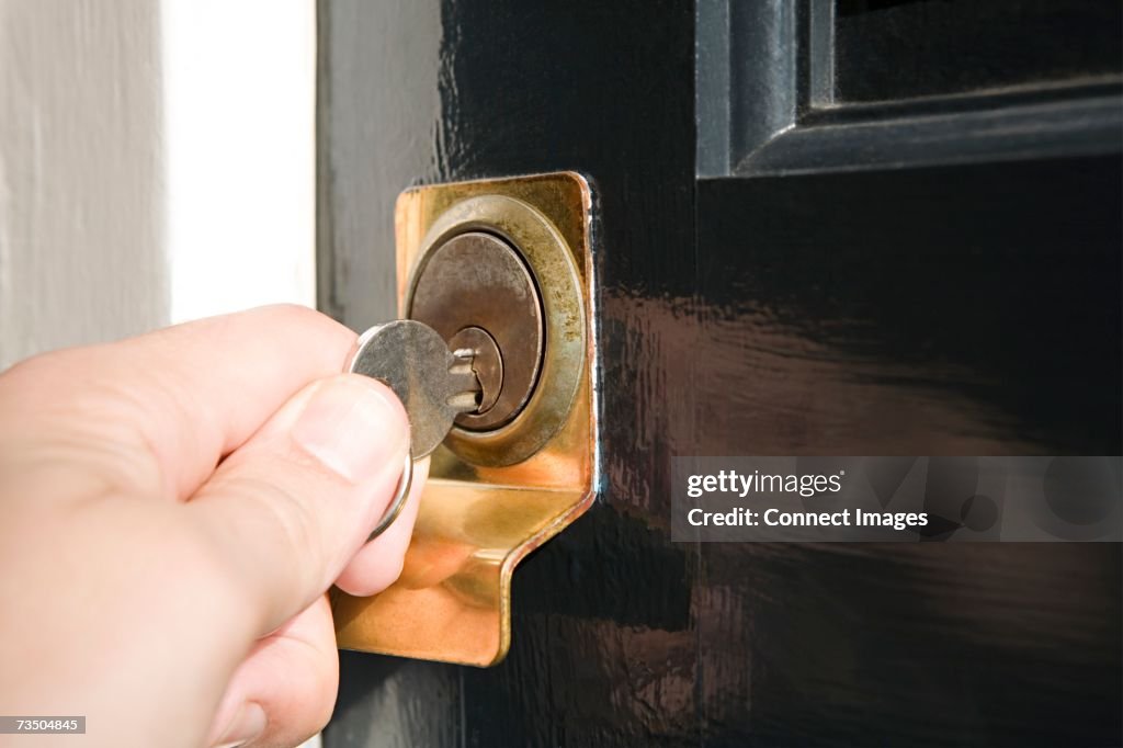 Person putting key in keyhole