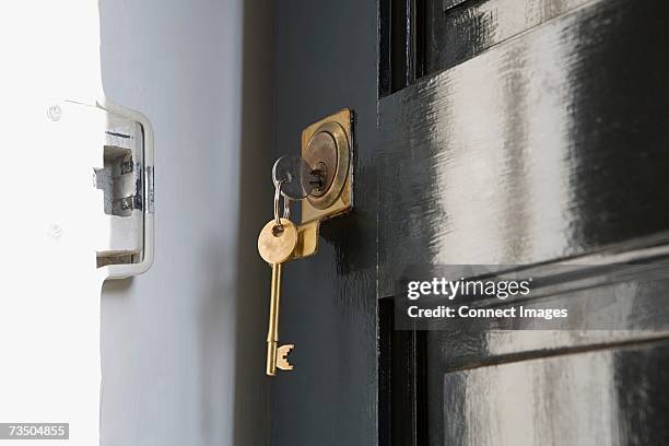 key in open door - cerradura fotografías e imágenes de stock