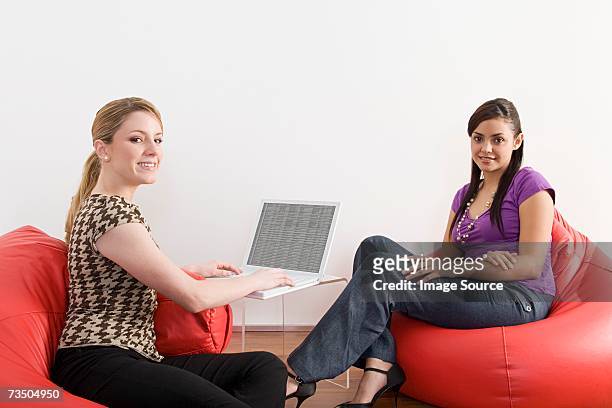 two female office workers on beanbags - red office chair stock pictures, royalty-free photos & images