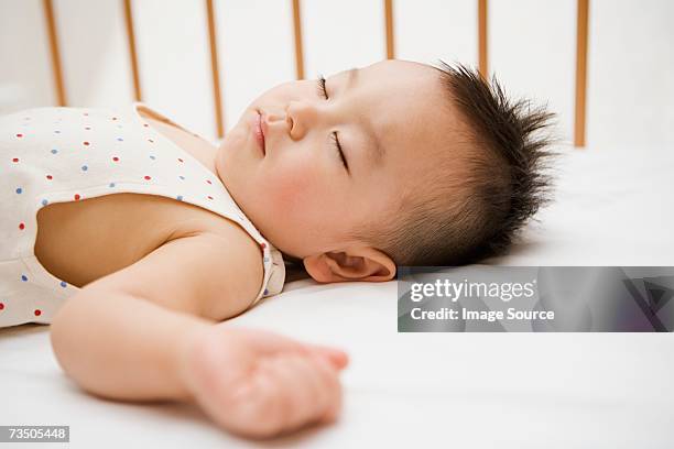 boy sleeping in crib - baby crib stockfoto's en -beelden