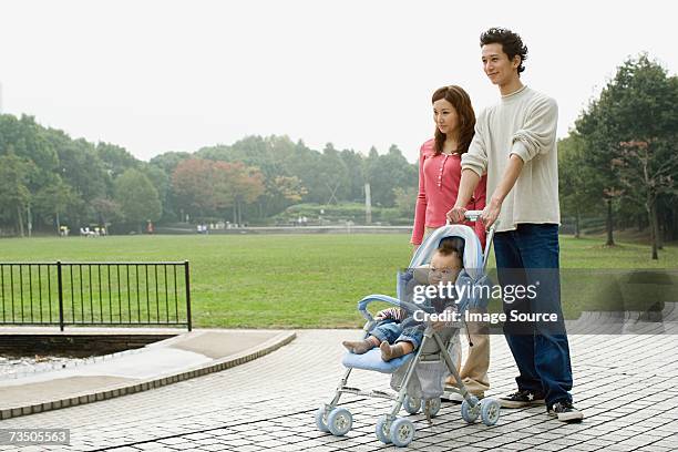 parents with baby in park - baby pram in the park stock pictures, royalty-free photos & images