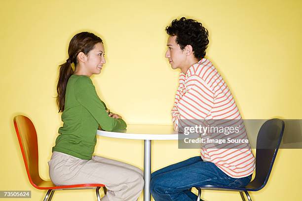 young couple face to face at table - gezicht aan gezicht stockfoto's en -beelden