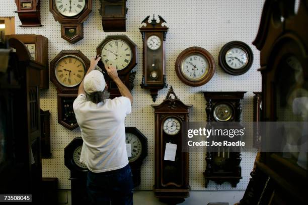 Mark Brown adjusts clocks on the wall at Brown?s Old Time Clock Shop March 6, 2007 in Plantation, Florida. This year day light savings time happens...