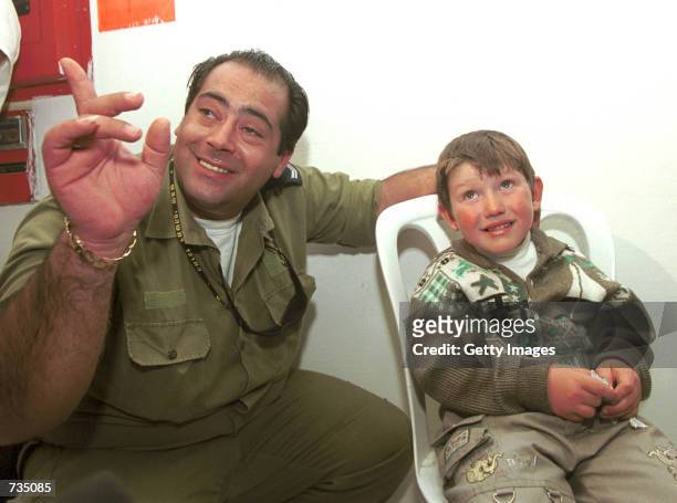 An Israeli soldier tries to entertain a young boy, one of the 57 hijacked passengers and crew on a hijacked flight from Dagestan, November 12, 2000...