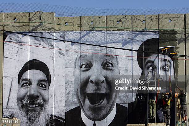 French artists from the "Face2Face" project paste giant posters of a Palestinian Muslim cleric , an Arab Christian priest and an Israeli Jewish rabbi...