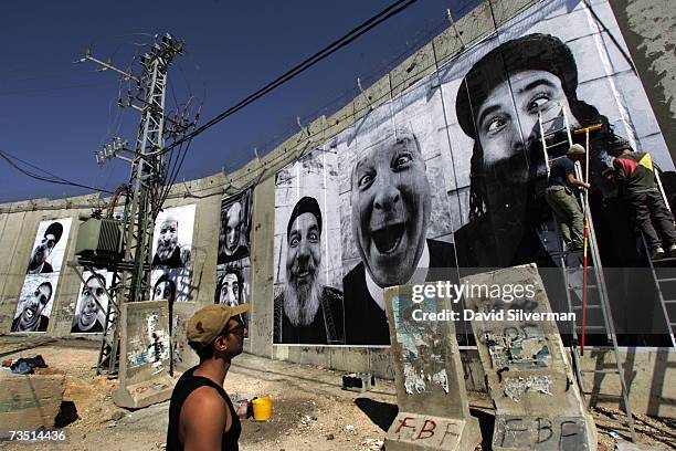 French artists from the "Face2Face" project paste giant posters of a Palestinian Muslim cleric , an Arab Christian priest and an Israeli Jewish rabbi...
