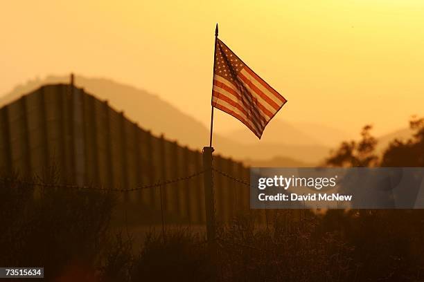 Flag put up by activists who oppose illegal immigration flies near the US-Mexico border fence in an area where they search for border crossers...