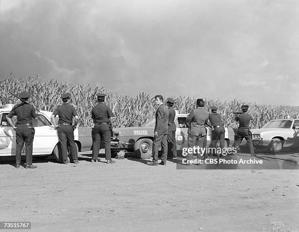 American actor Jack Lord , born John Joseph Patrick Ryan, in character as Steve McGarrett amid other actors dressed as police officers during the...