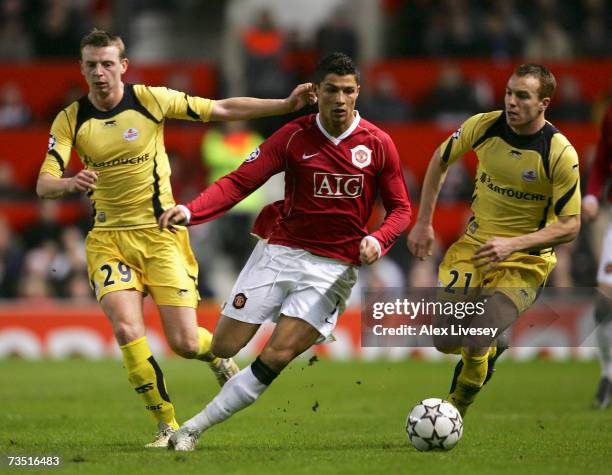 Cristiano Ronaldo of Manchester United surges past Stephane Dumont and Matthieu Chalme of Lille during the UEFA Champions League round of sixteen,...