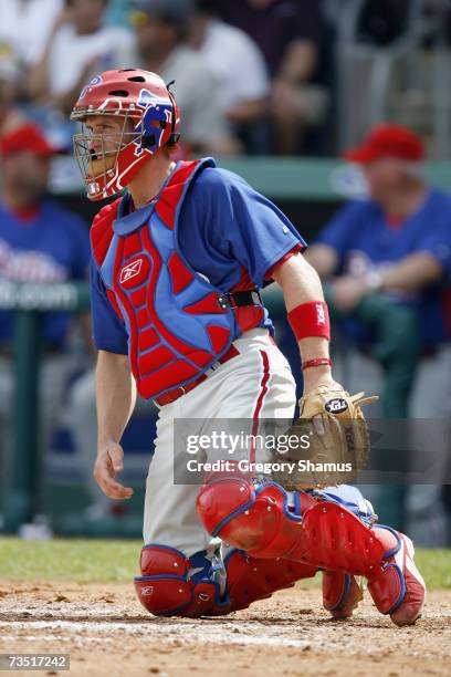 Catcher Chris Coste of the Philadelphia Phillies kneels behind the plate against the Boston Red Sox during a Spring Training game at City of Palms...