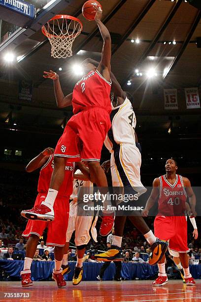 Anthony Mason Jr. #2 of the St. Johns Red Storm draws contact from Ousmane Barro of the Marquette Golden Eagles during the first round of the Big...