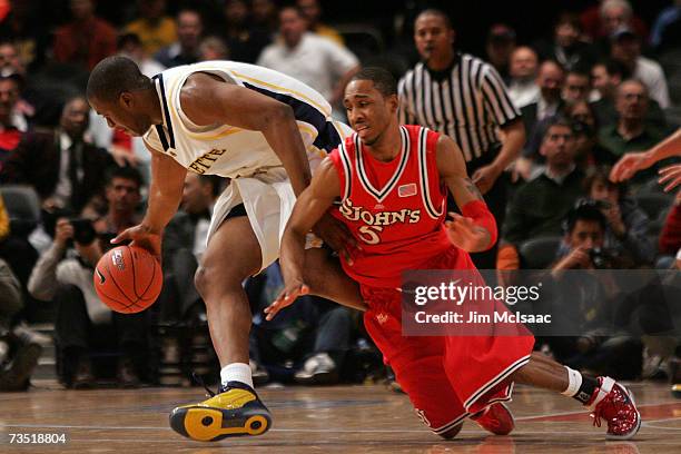 Larry Wright of the St. Johns Red Storm fights for the ball with Dwight Burke of the Marquette Golden Eagles during the first round of the Big East...