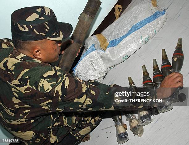 Zamboanga, PHILIPPINES: A Philippine military personel checks 10 pieces of 60mm mortar ammunition at a military base in southern Zamboanga city, 08...