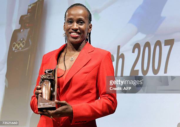 Lausanne, SWITZERLAND: Six-time Olympic medallist USA Jackie Joyner-Kersee smiles with the trophy she received during the ceremony of the 2007...