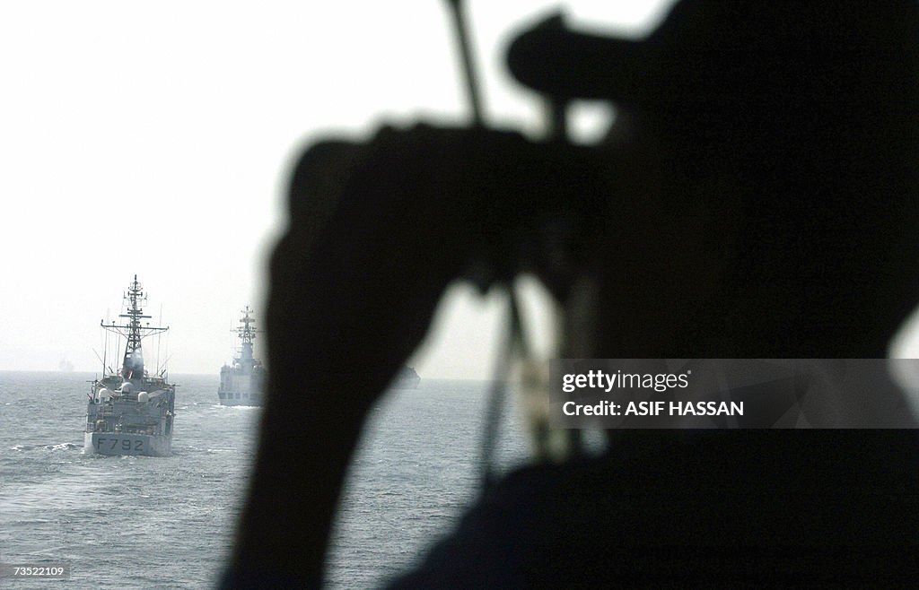 A Pakistani Navy official watches differ...