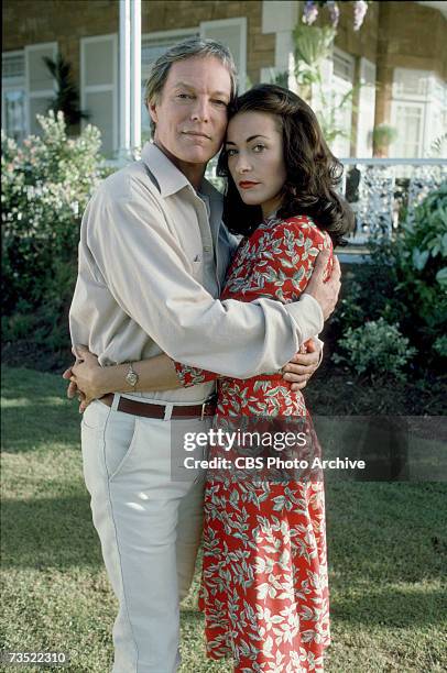 Promotional portrait of American actor Richard Chamberlain and British actress Amanda Donohoe as they embrace in a garden for the television...