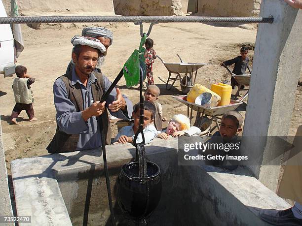 Locals operate a well built by German relief organization Welthungerhilfe as part of a so-called National Solidarity Program on August 28, 2005 near...