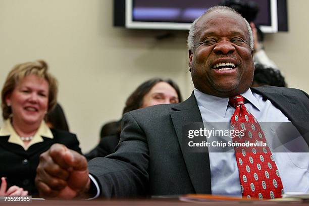 Supreme Court Justices Clarence Thomas laughs at a joke about baseball told between members of the House Financial Services and General Government...