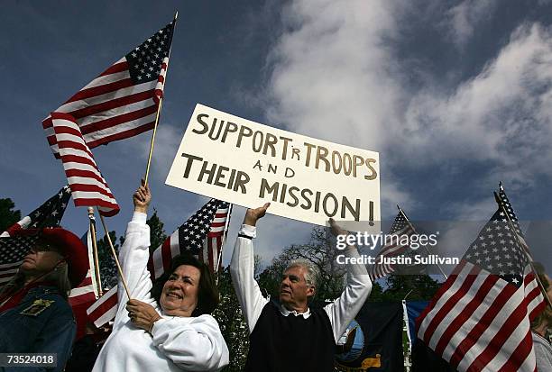 Pro-war demonstrators hold signs and flags during a demonstration at the site of a hillside with wooden crosses honoring U.S. Troops killed in Iraq...
