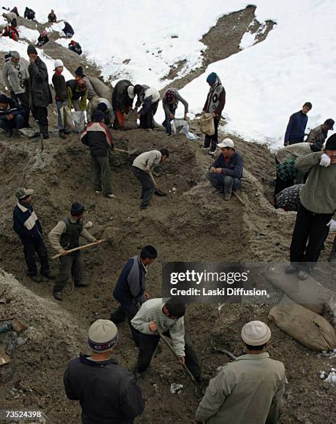 Kyrgyz labourers use hand tools to dig out traces of nickel from the ruins of an old Russian electrolamp plant, in this photo taken in January 2007...