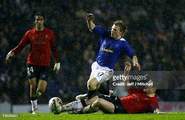 Chris Burke of Rangers is tackled by Inaki Munoz of Osasuna during the UEFA Cup last 16, first leg match between Rangers and Osasuna at Ibrox Stadium...
