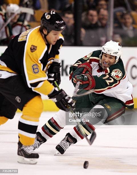 Brian Rolston of the Minnesota Wild tries to knock the puck away from Dennis Wideman of the Boston Bruins on March 8, 2007 at the TD Banknorth Garden...