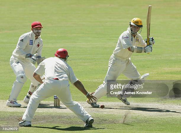Chris Rogers of the Warriors hits the ball past Mark Cosgrove of the Redbacks during day two of the Pura Cup match between the South Australian...