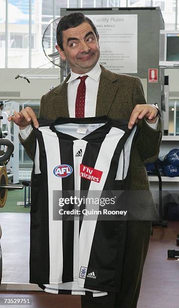 Actor Rowan Atkinson in character as Mr. Bean shows his delight after being presented with a Collingwood Magpies guernsey by Nathasn Buckley of the...