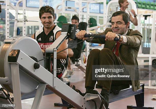 Actor Rowan Atkinson in character as Mr Bean trains on the rowing machine with Brodie Holland of the Magpies during the Collingwood Magpies AFL...