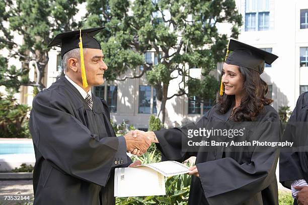 dean presenting student with diploma at graduation ceremony - college awards foto e immagini stock