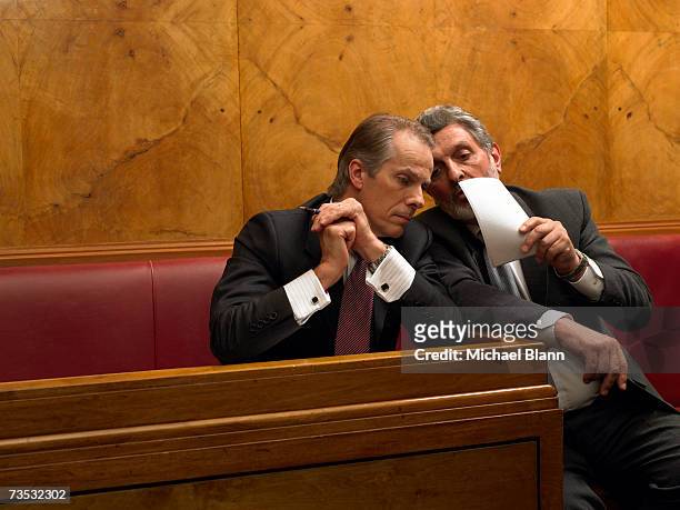 mature man whispering to colleague in pew - politician stockfoto's en -beelden