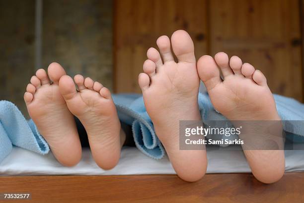 two children (6-12) lying in bed, focus on feet, close-up - tween heels stock pictures, royalty-free photos & images
