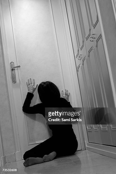 woman sitting in corridor with hands on closed door, asking for help - stuck door stock pictures, royalty-free photos & images