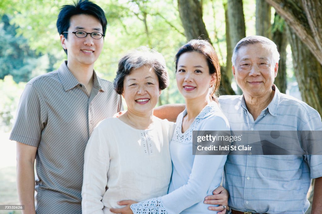 Senior couple standing with adult daughter and son-in-law, smiling, portrait