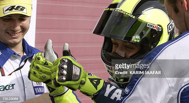 Yamaha MotoGP rider and five-time world champion Valentino Rossi of Italy celerbates following the qualifying session at the Losail Circuit in Doha,...