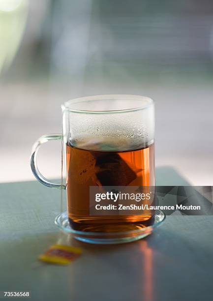 cup of tea containing tea bag - herbal tea bag stock pictures, royalty-free photos & images